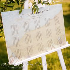 a seating sign with flowers and greenery on it for an outdoor wedding ceremony at the beach