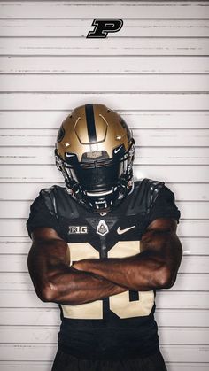 a football player with his arms crossed in front of the camera, wearing a black and gold uniform