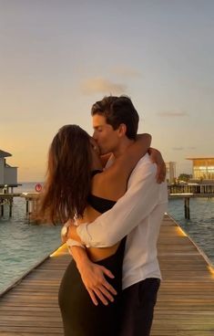 a man and woman embracing on a dock