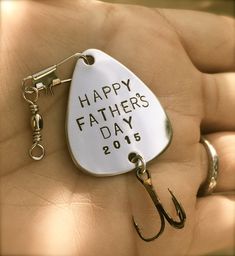 a happy father's day fishing keychain is shown in someones hand