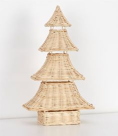 a small wicker christmas tree on a white surface