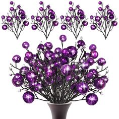 a vase filled with purple ornaments on top of a table