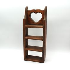 a wooden shelf with a heart cut out on the top and bottom shelves, against a white background