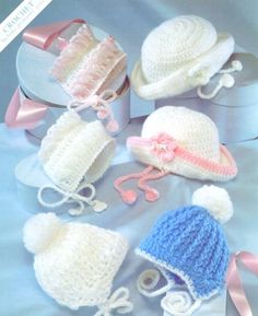 crocheted baby hats and bonnets are displayed on a blue background with pink ribbons