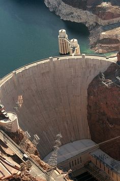 a man standing at the top of a large dam looking down on it's surroundings