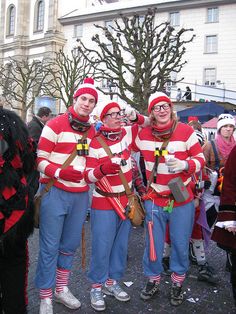 three people dressed in red and white striped sweaters are standing next to each other