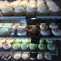 a display case filled with lots of different types of cupcakes