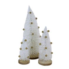 three white christmas trees with gold decorations