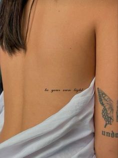 the back of a woman's shoulder with a tattoo saying for your own flight