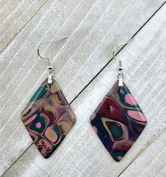 two square shaped earrings with colorful designs on them