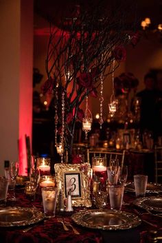 the table is set with candles, plates and silverware for an elegant wedding reception