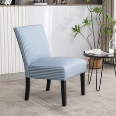 a blue striped chair sitting on top of a carpeted floor next to a table