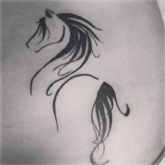 a black and white photo of a woman's stomach with a horse tattoo on it