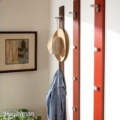 a coat rack with hats hanging on it next to a window and potted plant