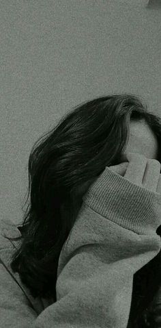 a black and white photo of a woman covering her face