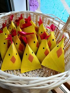 small yellow paper cones with red bows in a wicker basket on top of a table