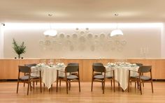 a dining room set up with round tables and chairs, white linens on the table