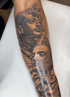 an egyptian tattoo on the leg of a person with a headdress and two faces