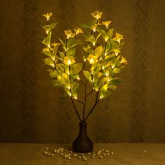 a vase filled with yellow flowers sitting on top of a table next to some beads