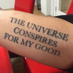 a person with a tattoo on their arm that says the universe conspires for my good