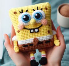 someone is holding up a crocheted spongebob cell phone case in their hand