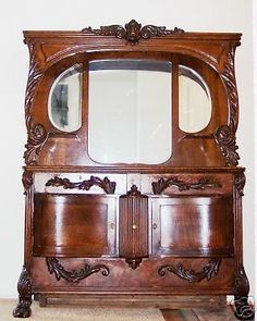 an old wooden cabinet with mirror on top