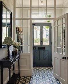 an entry way with a blue door and tiled floor