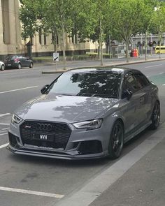 a grey car is parked on the side of the road