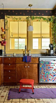 a kitchen with wooden cabinets and colorful rugs