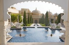 an outdoor swimming pool surrounded by white arches