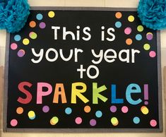 this is your year to sparkle sign with pom poms on the top and bottom