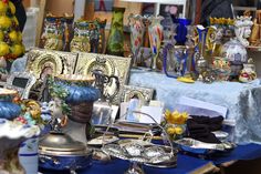 there are many items on the table for sale in this market place, including figurines and vases