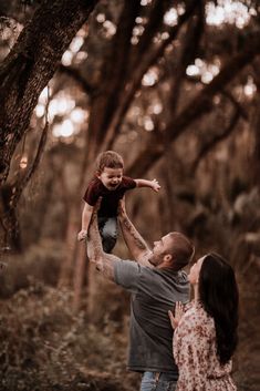 a man holding a little boy up in the air