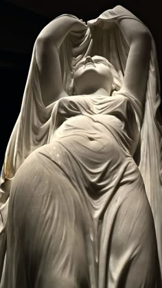 the statue is covered in white cloths and has her hands on her head as she sleeps