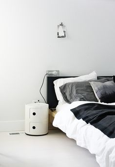 a bed with black and white comforter next to an air puke heater