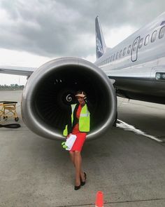 a woman is standing in front of an airplane