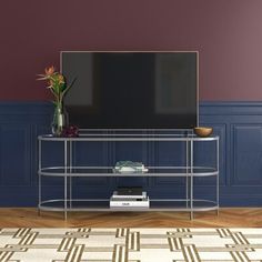 a living room with purple walls and a gold tv stand