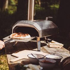 a pizza is being cooked in an outdoor oven