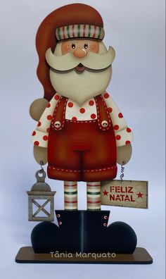 a santa clause figurine holding a sign that says feliz natal