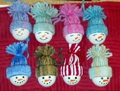 six snowmen with hats and scarves are on a red towel next to a brown teddy bear