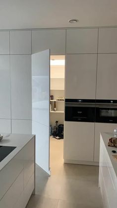 a kitchen with white cabinets and counter tops