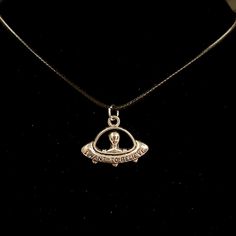 a silver necklace with an emblem on it