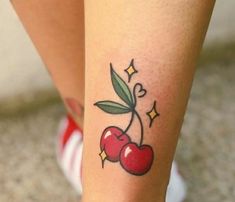 a small cherry tattoo on the leg