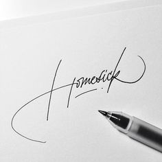 a close up of a pen on top of a piece of paper with the word pencil written in cursive writing