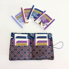 four packets of twinings sitting on top of each other in front of a wallet