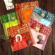 four different colored napkins with brooches on them sitting next to each other