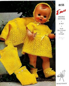 an old fashioned baby doll in yellow knitted outfit and booties with matching socks