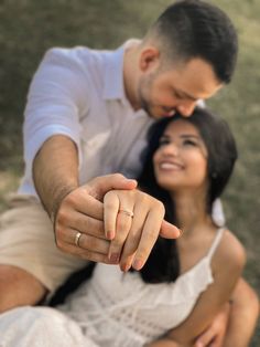 a man and woman pointing at the camera with their fingers in each other's hand