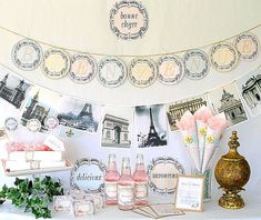 a table topped with lots of bottles and vases next to a white cloth covered wall