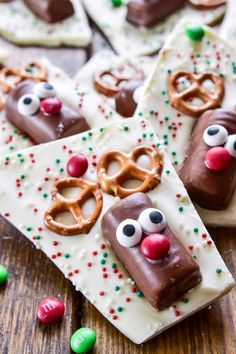 reindeer pretzels are decorated with chocolate and sprinkles on a wooden table